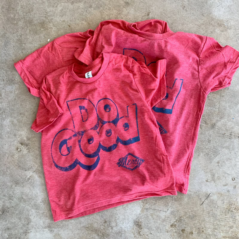 Red Mercy Goods Do Good t-shirts on the shop floor