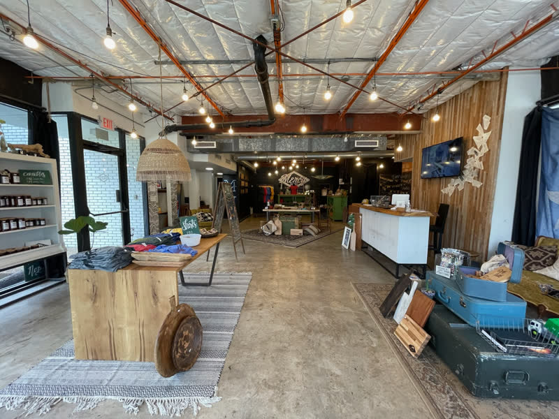 A wide view of the Mercy Goods retail shop, from the merch tables to the counter
