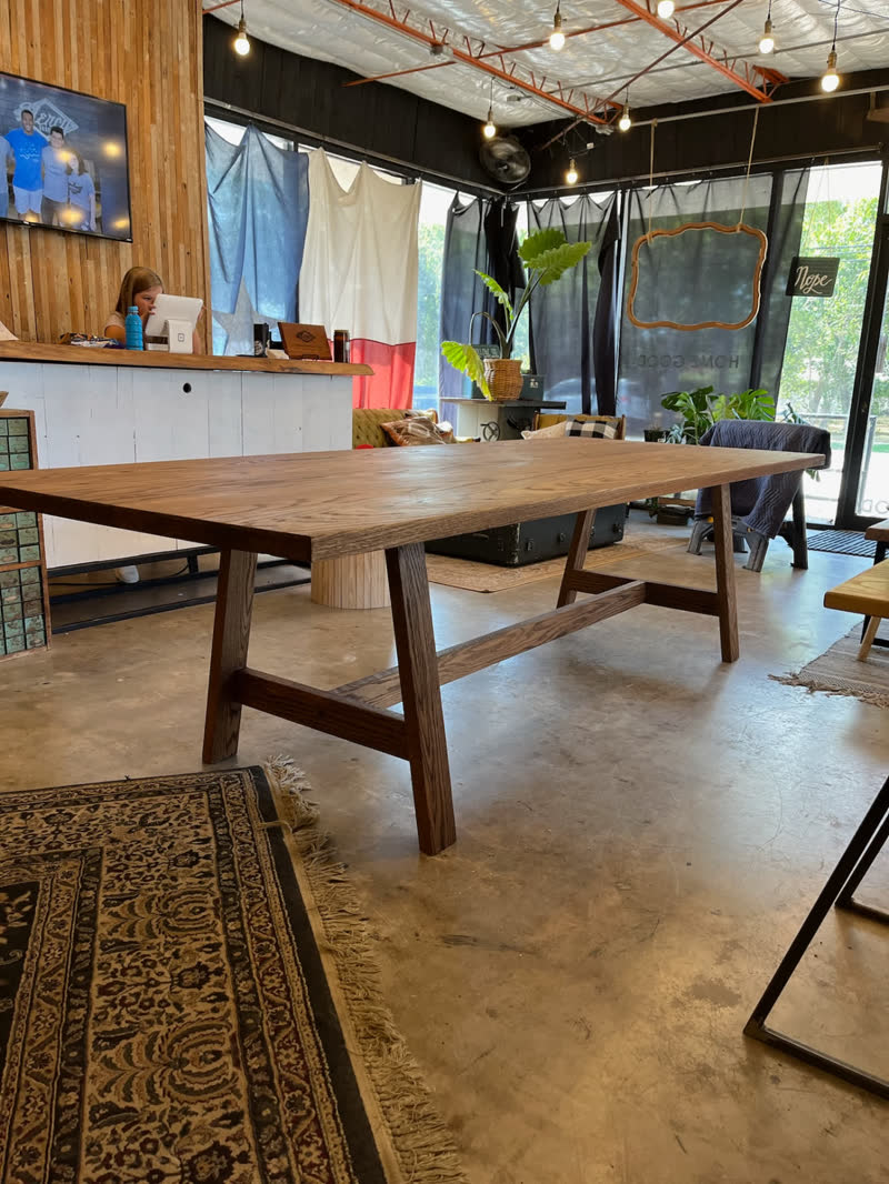 A long oak dining table on display in the Mercy Goods retail shop