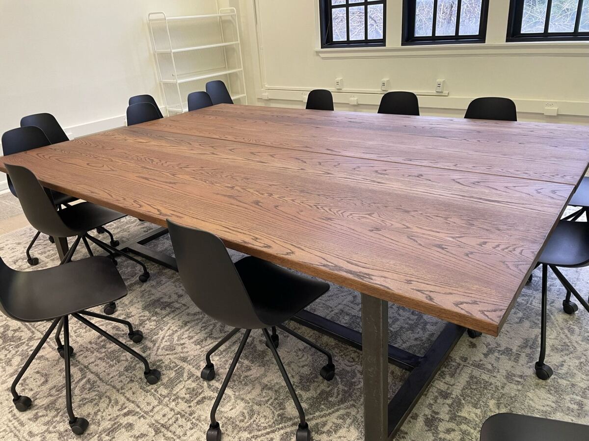 A custom walnut conference table built in the Mercy Goods workshop, delivered to a client